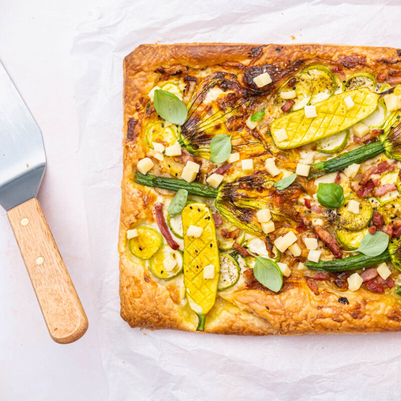 Bladerdeegtaart met mini-courgettes, courgettebloemen & emmental